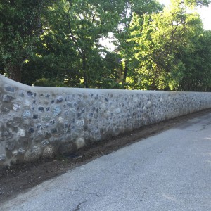 Réalisation d'un mur de clôture en pierre de récupération en double parement 